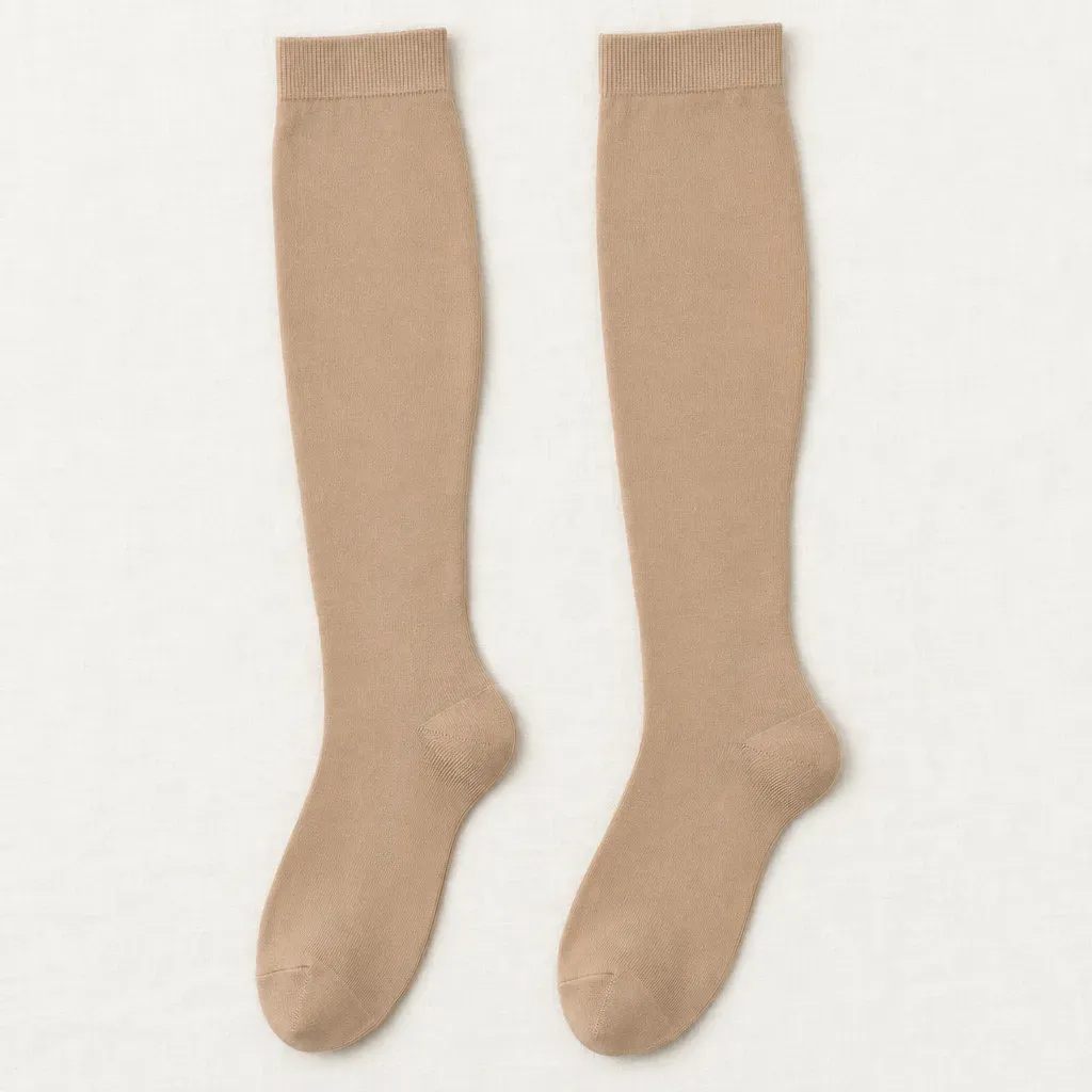 A pair of beige firm knee-high compression socks laid flat